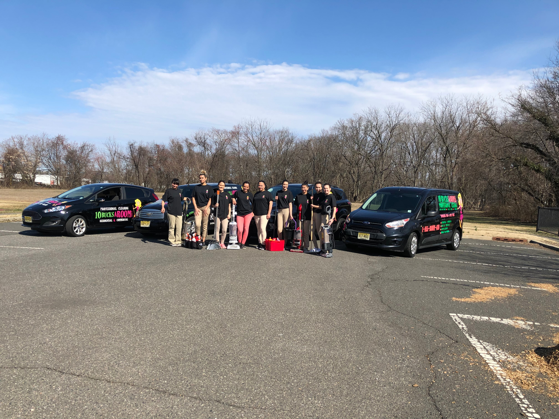 A 10BucksaRoom crew with their fleet of branded vehicles, vacuums and supplies.