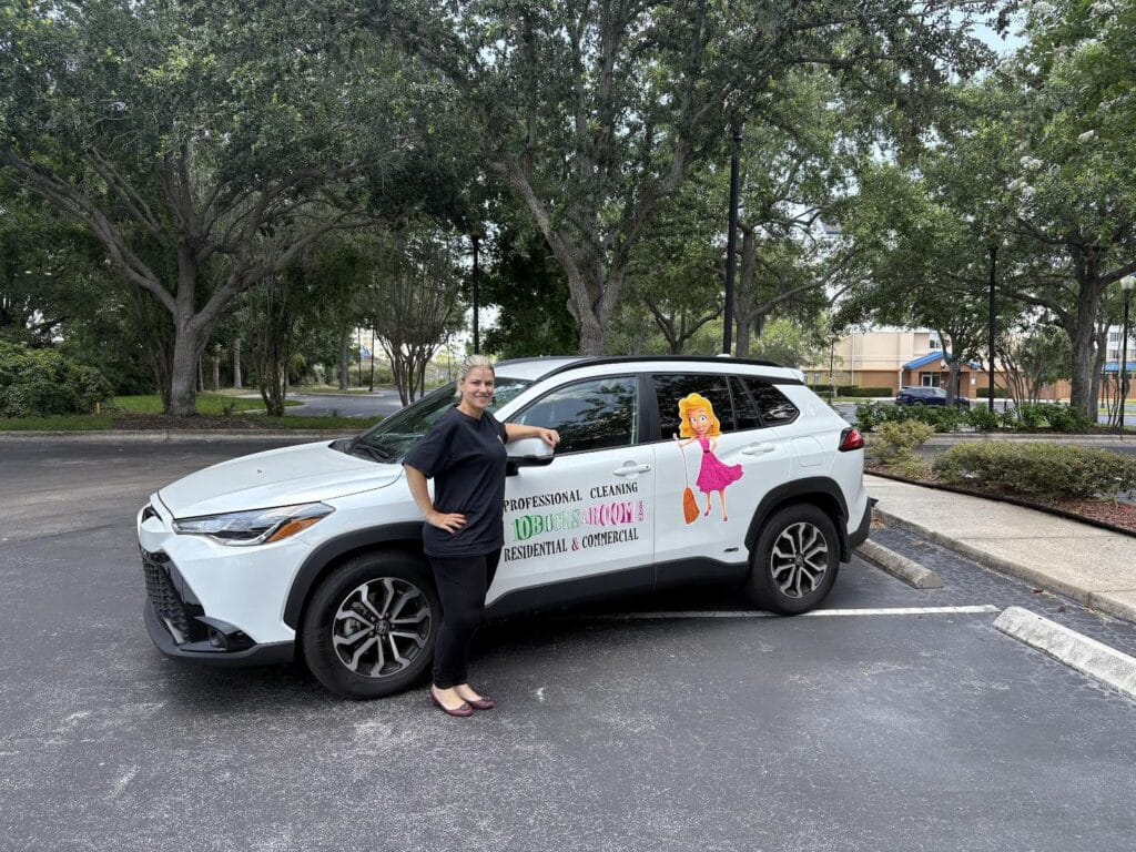 Cleaning girl standing infront of his promotional 10bucksaroom's car.